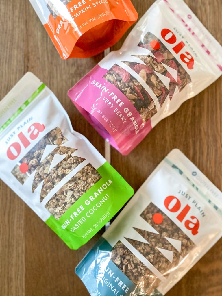 All four flavors of Just Plain Ola in 9oz bags: Toasted Coconut, Pumpkin Spice, Very Berry and Original Cinnamon